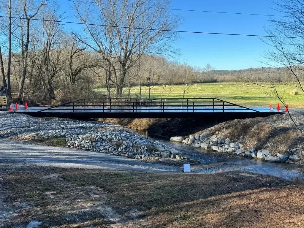 A residential bridge over a creek with construction cones and equipment in a rural Middle Tennessee setting.